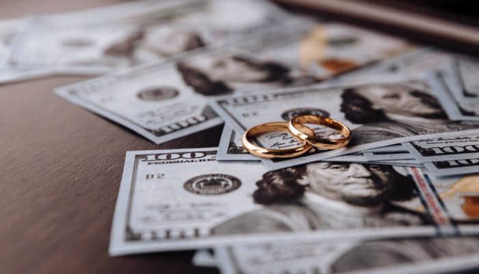 Wedding rings on money background, close up