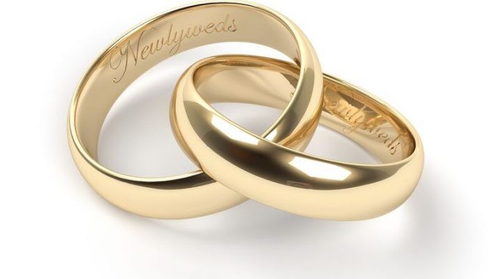 15870840 - gold wedding rings engraved with the text newlyweds